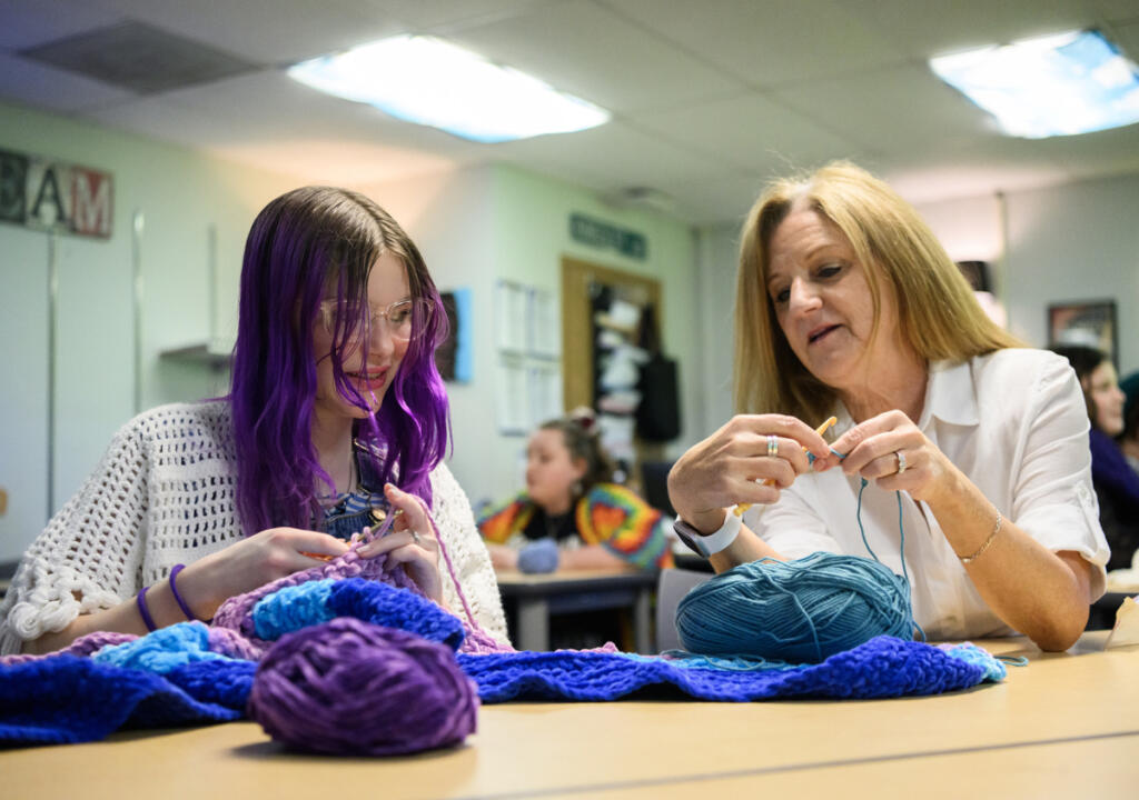 English teacher Ellie Kingsley, right, crochets with eighth-grader Millie Derheimer on March 24 during a crochet club meeting at Pacific Middle School. (Taylor Balkom/The Columbian)