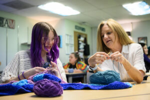 English teacher Ellie Kingsley, right, crochets with eighth-grader Millie Derheimer on March 24 during a crochet club meeting at Pacific Middle School. (Taylor Balkom/The Columbian)