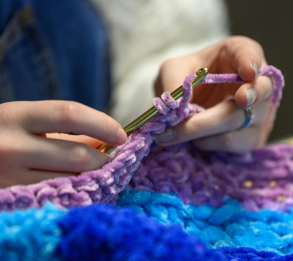 Eighth-grader Millie Derheimer crochets March 24 during a crochet club meeting at Pacific Middle School. (Taylor Balkom/The Columbian)