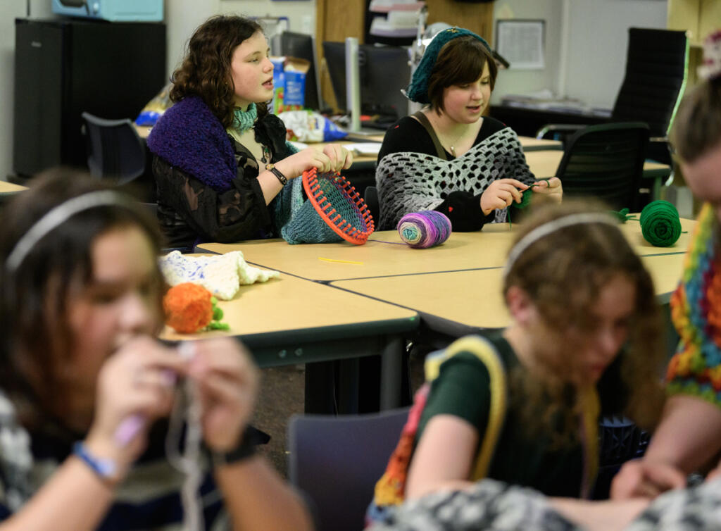 Sixth-graders Abigail Westman, left, and June Mathena sing a tune from &ldquo;K-Pop Demon Hunters&rdquo; while crocheting on March 24 during a crochet club meeting at Pacific Middle School. The girls in the club say that keeping their hands busy helps them feel calm and focused. (Photos by Taylor Balkom/The Columbian)