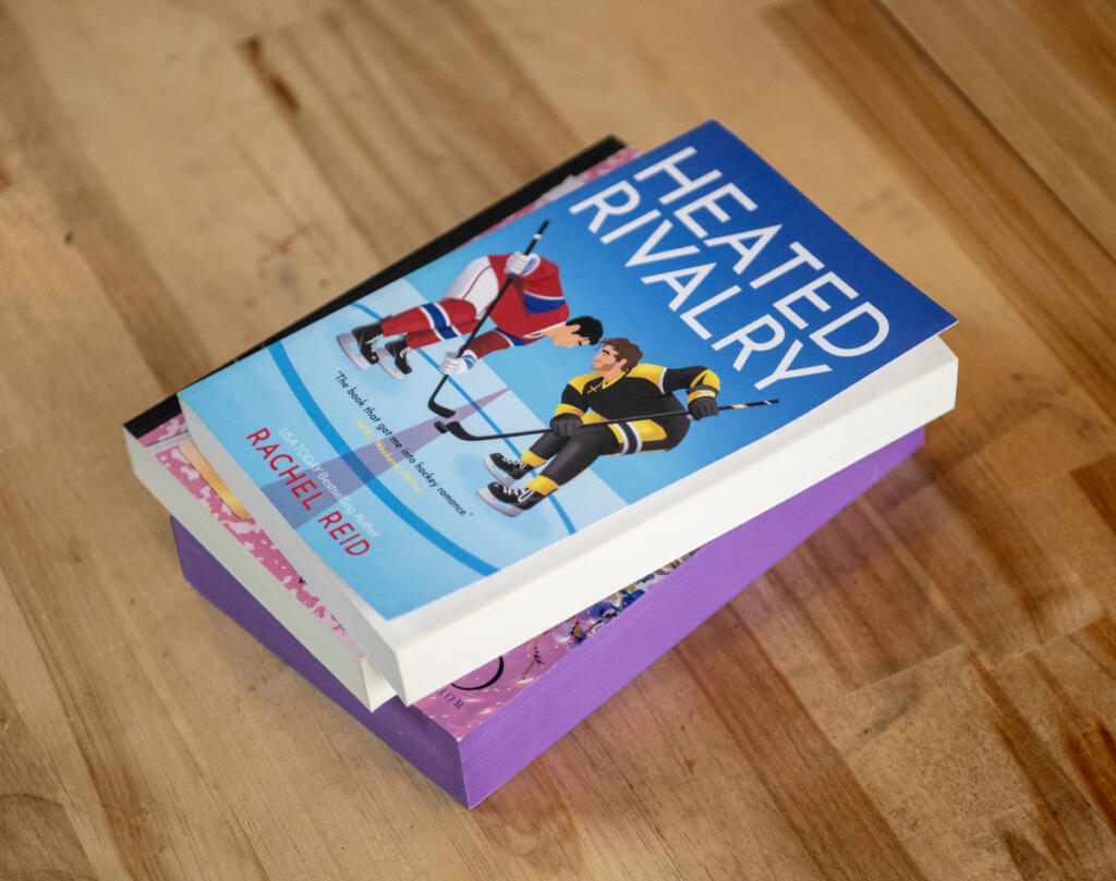 A stack of romance novels sit on a table April 1, 2026, before a meeting of the Romance Readers Social Club at Ashwood Taps and Trucks in Washougal. (Taylor Balkom/The Columbian)