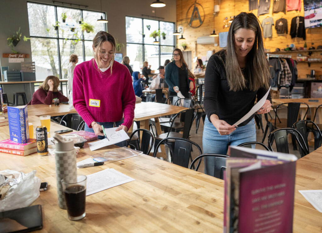 Romance Readers Social Club hosts Emily Lemucchi, left, and Megan Davis set up tables April 1 before a meeting at Ashwood Taps and Trucks in Washougal.