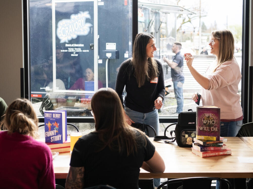 Romance Readers Social Club host Megan Davis, second from left, chats with Erica Karns of Washougal on April 1 before a meeting at Ashwood Taps and Trucks in Washougal. (Taylor Balkom/The Columbian)