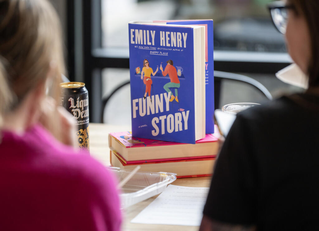 A stack of romance books sits on a table April 1 during a Romance Readers Social Club meeting. (Taylor Balkom/The Columbian)
