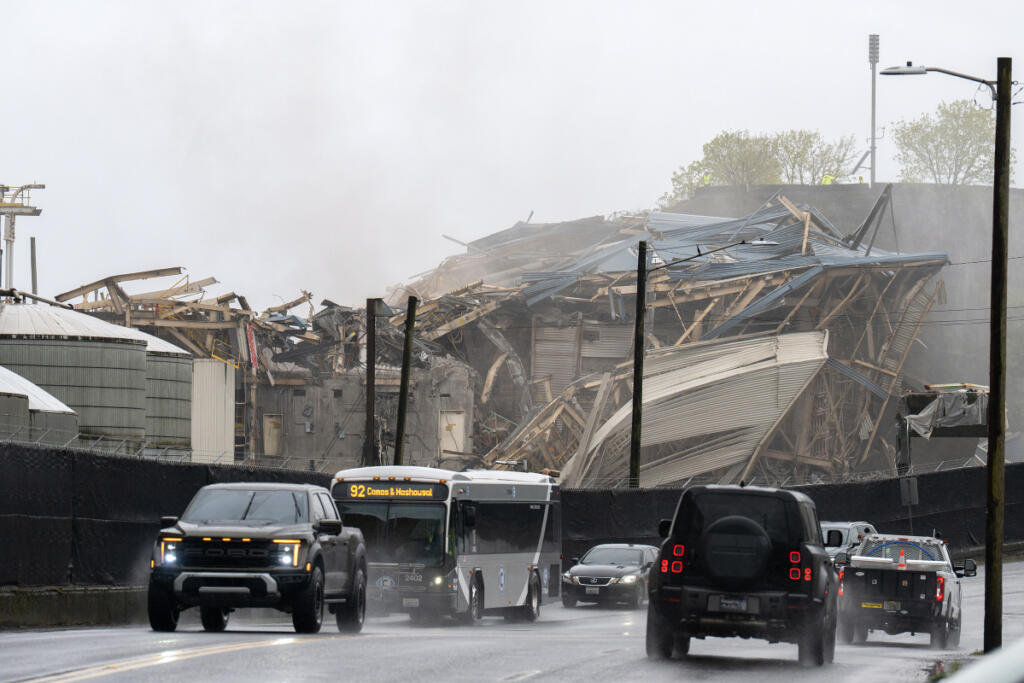 Drivers pass the site of the controlled boiler fall at the Georgia-Pacific Camas Mill after the road was reopened Wednesday morning. Several bystanders, city of Camas workers and Georgia-Pacific staff watched the fall from afar. It took only about 10 seconds for the boiler to crash down. (Amanda Cowan/The Columbian)