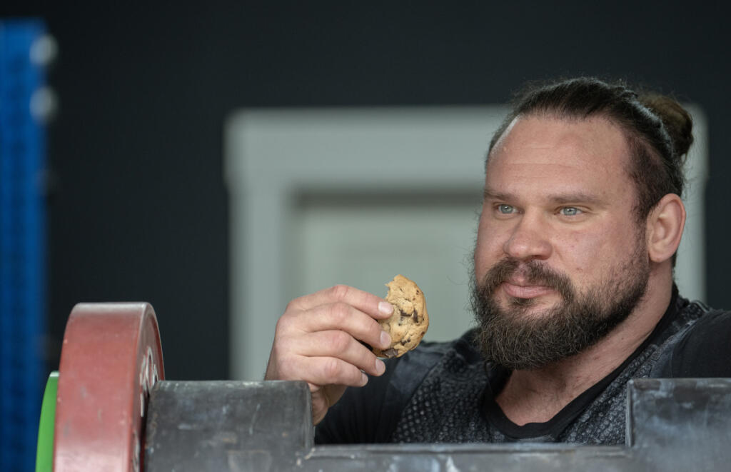 Camas resident Martins Licis takes a cookie break while recording a livestreaming workout for his followers at his home. (Photos by Amanda Cowan/The Columbian)