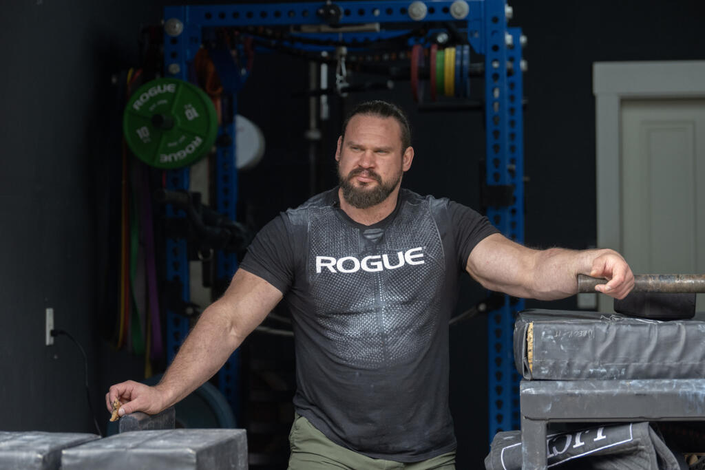 Camas resident Martins Licis takes a cookie break while recording a livestreaming workout for his followers. (Amanda Cowan/The Columbian)