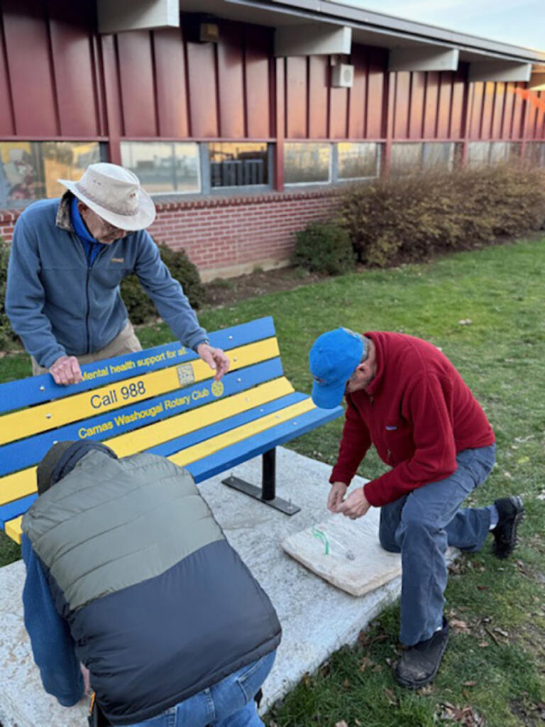 Camas-Washougal Rotarians Richard Renton, left, Clay Heinz, center, and David Bussman install a &ldquo;buddy bench&rdquo; at Liberty Middle School in Camas. (Contributed by George Capacci)