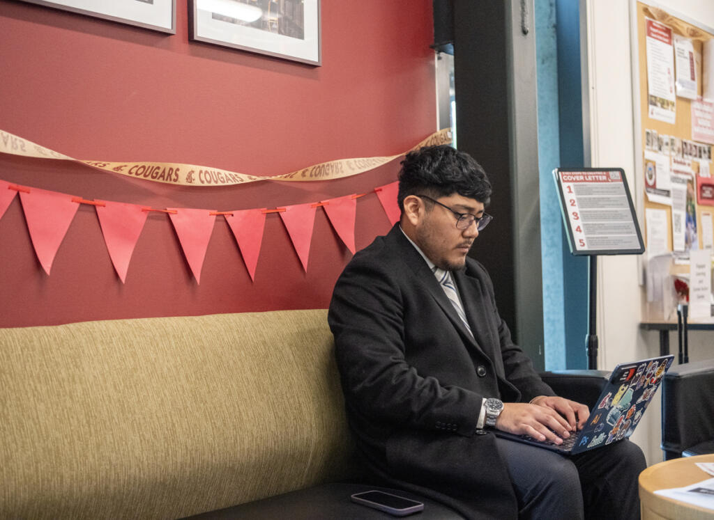 Washington State University Vancouver human development and digital technology and culture senior Joseph Reyes-Hernandez works on a computer April 14 at WSU Vancouver&rsquo;s Career Action Center. (Taylor Balkom/The Columbian)