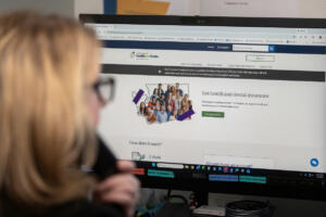 Marlena Close of Applied Team Insurance logs into her computer while checking her voicemail in Hazel Dell Feb. 3. (Amanda Cowan/The Columbian files)