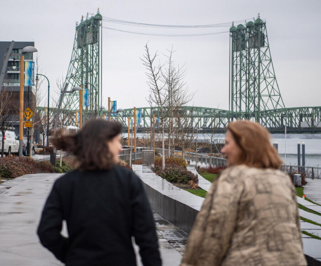 The I-5 Bridge rises above the Columbia River as Rep. Marie Gluesenkamp Perez, D-Skamania, left, and Vancouver Mayor Anne McEnerny-Ogle converse Jan. 13, 2023, during a tour of key infrastructure projects in Perez&rsquo;s district. (Taylor Balkom/The Columbian files)