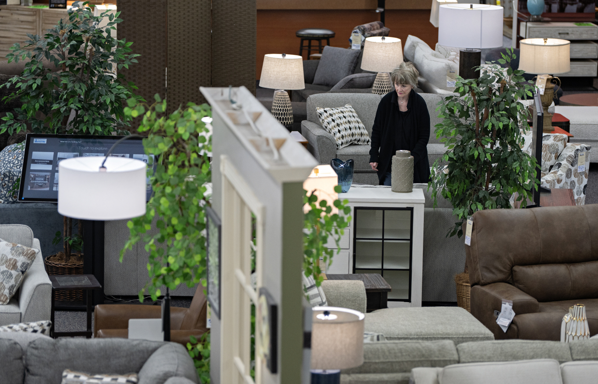 Molly Fletcher of One Stop Home Furnishings in Camas prepares the showroom for customers on April 20. Furniture stores are facing difficulties with uncertainty, slumping demand and rising freight costs. (Amanda Cowan/The Columbian)