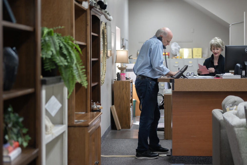 Dave Fletcher of One Stop Home Furnishings works with his wife, Molly, in Camas on April 20. Furniture stores are facing difficulties with uncertainty, slumping demand and rising freight costs.