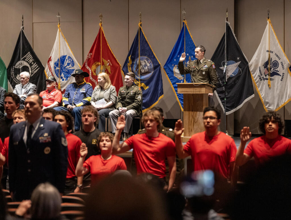 Lt. Col. John Scott, at podium, leads an oath of enlistment for military recruits April 22 during an event for future military service members at Skyview High School. About 90 high-schoolers were celebrated for enlisting in the military. (Taylor Balkom/The Columbian)