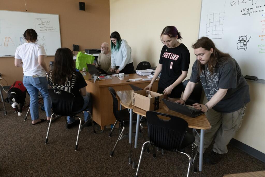 PAX Learning Center students Peyton Knight, second from right, and Braxton Hiley, right, prepare their laptops for class at Clark College&rsquo;s Columbia Tech Center campus on Monday afternoon. (Amanda Cowan/The Columbian)