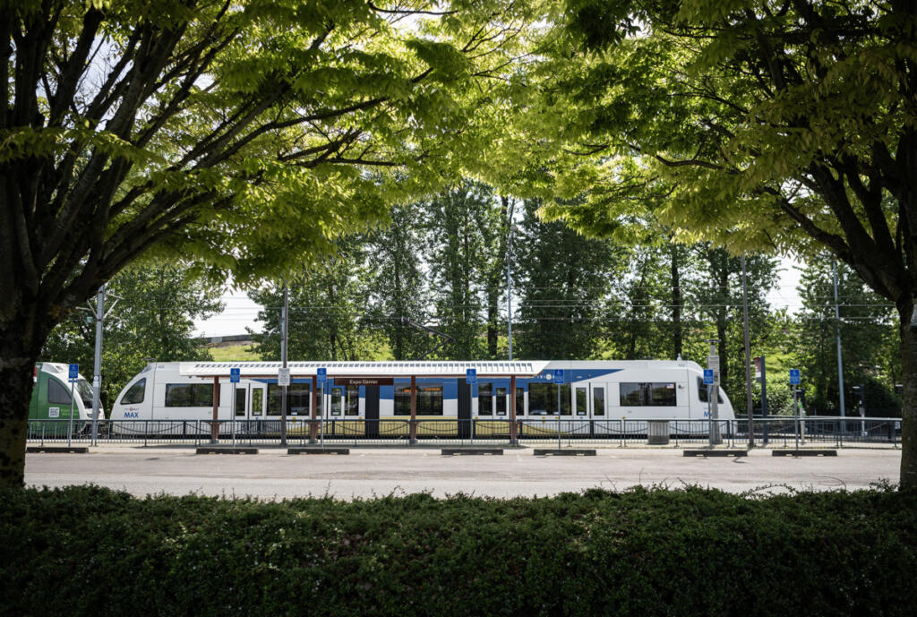 A MAX train at the northern end of the yellow line sits framed by trees May 1 at the Portland Expo Center Station. (Taylor Balkom/The Columbian)