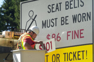 A Washington Department of Transportation worker changes the fine amount on a seat belt road sign south of Tumwater on July 17, 2003. The fine for not wearing a seat belt is now $150. (Associated Press files)