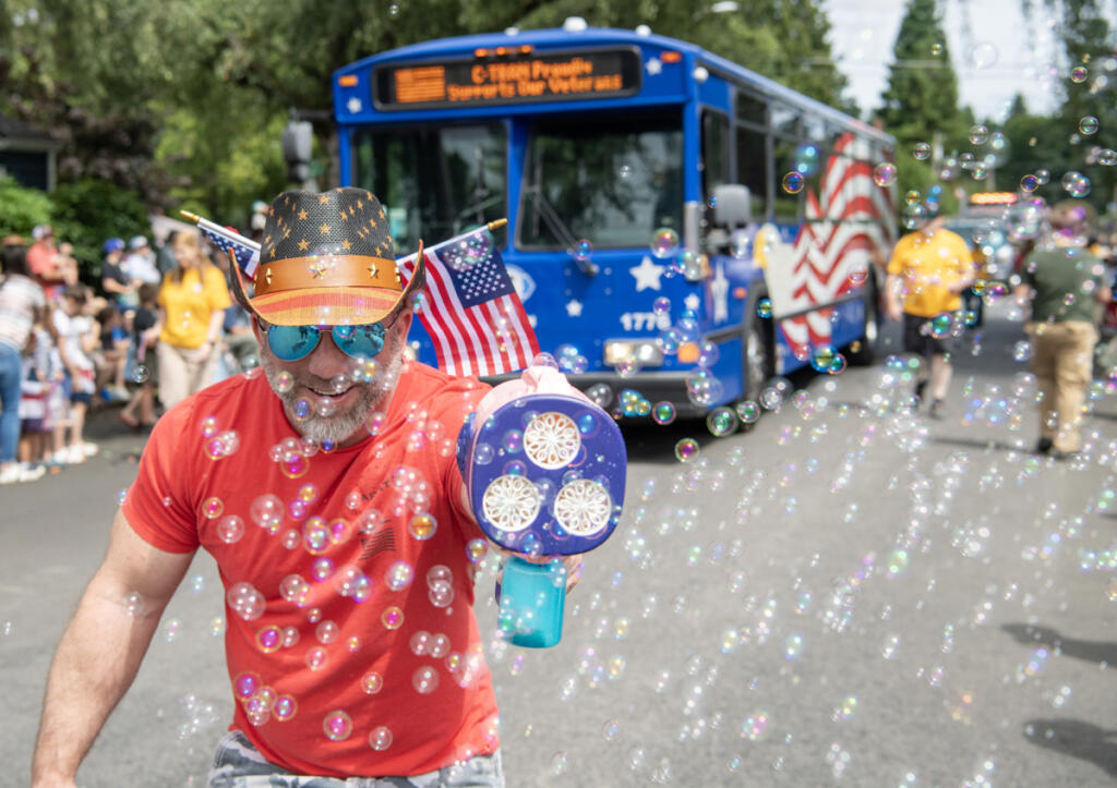 A participant in last year&rsquo;s Fourth of July parade in Ridgefield sprays bystanders with hundreds of bubbles. (Photos by Taylor Balkom/The Columbian files)