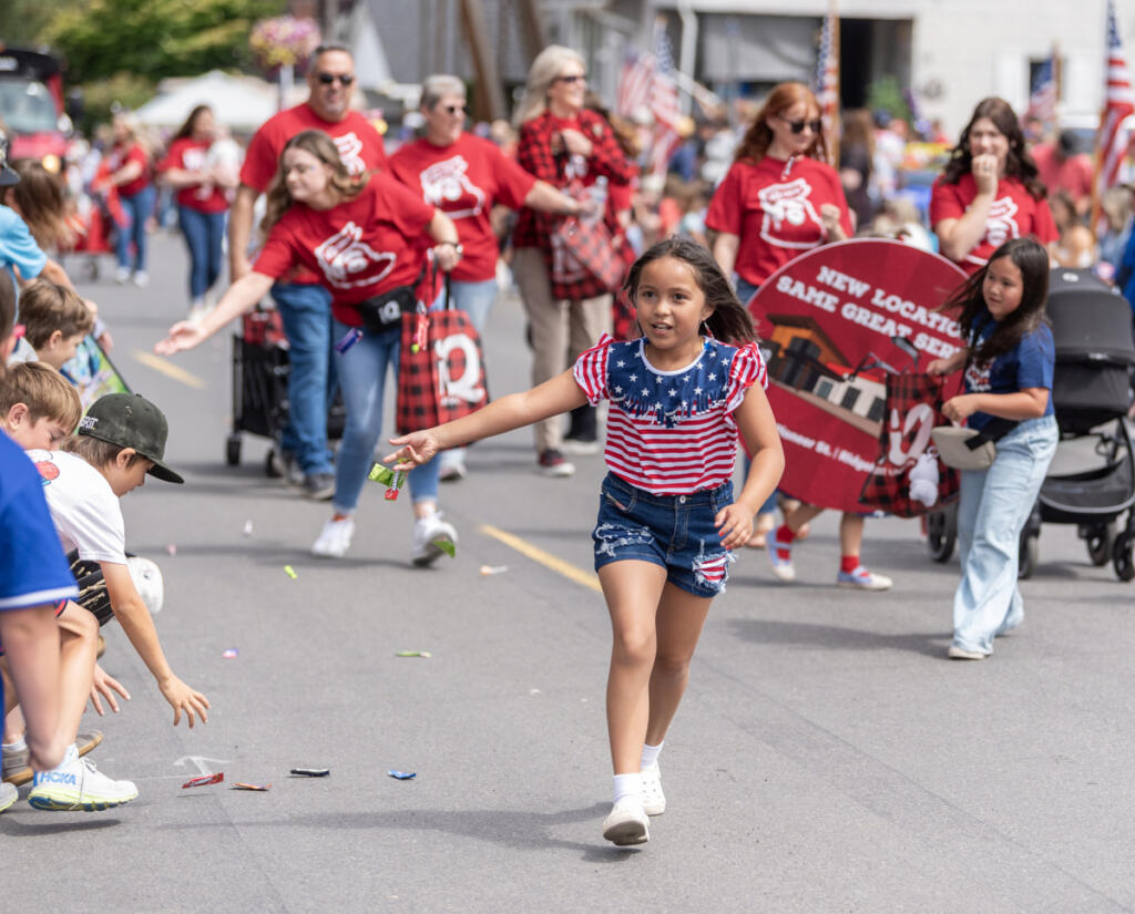 Ridgefield Fourth of July Parade participants hand out candy to kids during last year&rsquo;s festivities.