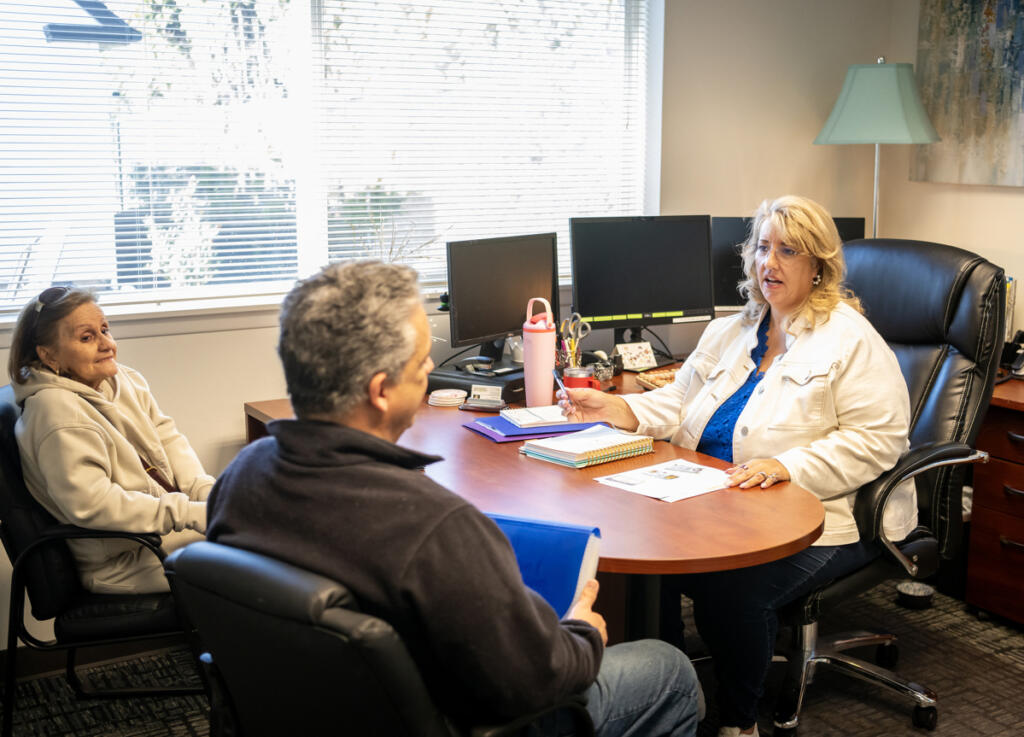 Owner Rachel Lauser, from right, talks with clients Peter and Maria Allain about insurance on Feb. 27 at Applied Team Insurance. (Photos by Taylor Balkom/The Columbian)