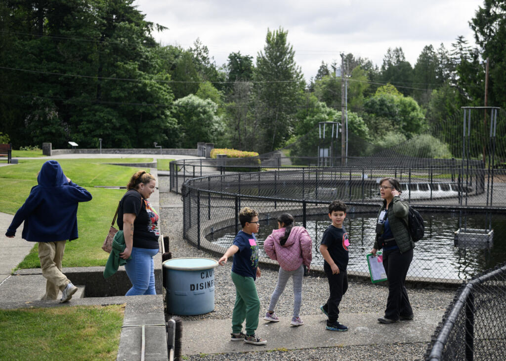 Environmental educator Jamie Austin, right, leads a group of Crestline Elementary first graders on a tour May 19 at the Columbia Springs Vancouver Trout Hatchery. (Taylor Balkom/The Columbian)
