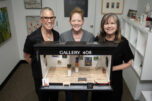 Curator and designer Lara Blair, from left, and Gallery 408 co-owners Michelle Purvis and Kim Nickens stand behind their new miniature gallery at Gallery 408 in Camas. The mini-gallery, which is having an official ribbon-cutting ceremony on June 5, will become part of the Worldwide Sidewalk Joy Project, which celebrates miniature art installations around the world. (Taylor Balkom/The Columbian)