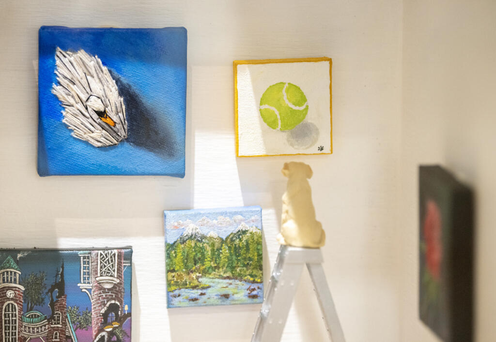 Miniscule stitches evoke the feathers of a swan in Michelle Purvis&rsquo; tiny artwork, regarded by a teensy dog atop a tiny stepladder inside the miniature Gallery 408. (Taylor Balkom/The Columbian)