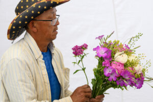 Richard Xiong arranges a bouquet June 3 at the Xiong Flower Farm booth at the Camas Farmers Market. &ldquo;We&rsquo;re so excited, even with the new location,&rdquo; said Leah Nichelson, the market&rsquo;s manager and vendor liaison. (Taylor Balkom/The Columbian)