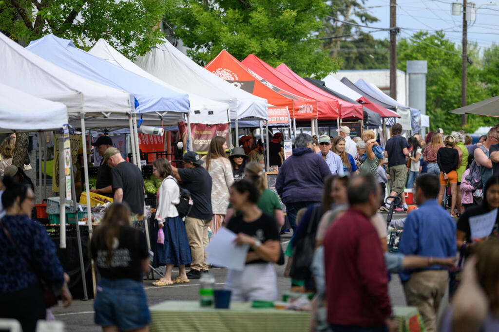 People check out booths June 3 at the Camas Farmers Market. The market temporarily relocated away from its location near City Hall due to construction. (Photos by Taylor Balkom/The Columbian)