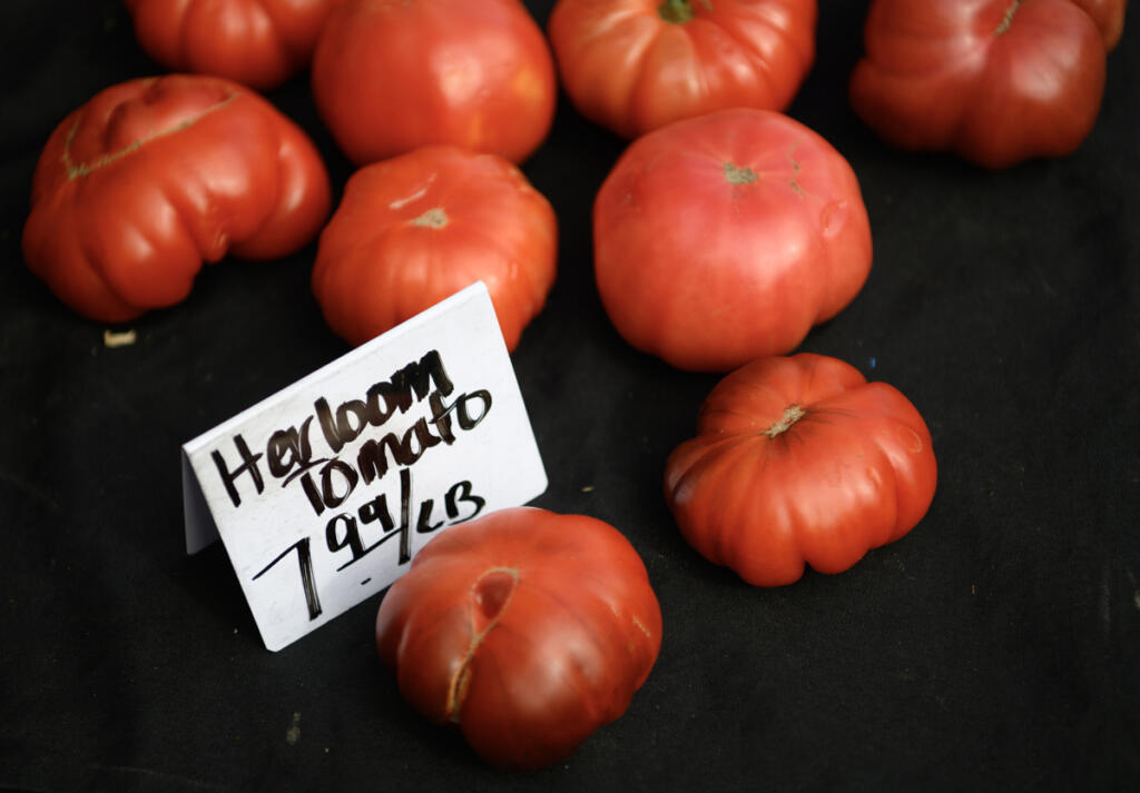 Heirloom tomatoes sit on a table June 3 at the Camas Farmers Market. (Taylor Balkom/The Columbian)