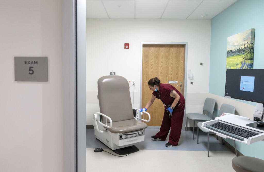 Medical assistant Alexi Skondin prepares an exam room for a patient while working at Vancouver Clinic&rsquo;s Salmon Creek Urgent Care facility June 4.