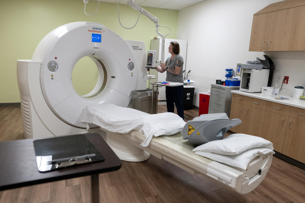 CT technician Kelly Chavez prepares the room for a patient while working at Vancouver Clinic&rsquo;s Salmon Creek Urgent Care facility June 4. (Photos by Amanda Cowan/The Columbian)