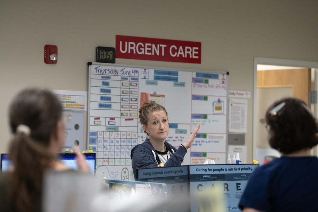 Clinical nurse lead Kim Fleshman talks with colleagues while getting the day started at Vancouver Clinic&rsquo;s Salmon Creek Urgent Care facility June 4. (Amanda Cowan/The Columbian)