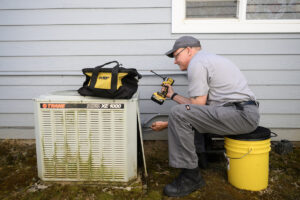 All Seasons Heating and Cooling service manager Ken Sullivan works on an air conditioning unit Friday in Camas. (Photos by Taylor Balkom/The Columbian)