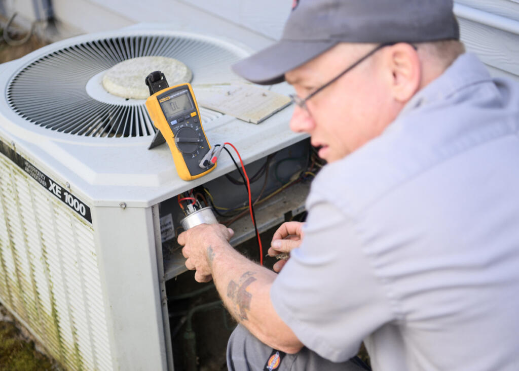 All Seasons Heating and Cooling service manager Ken Sullivan uses a multimeter during a service call Friday in Camas.