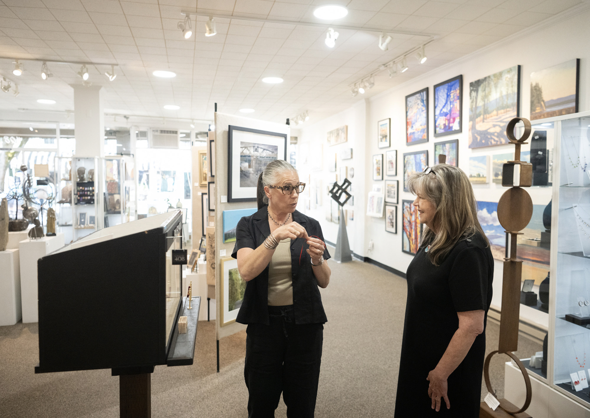 Curator Lara Blair, center, and gallery owner Kim Nickens chat May 27 next to a miniature Gallery 408 installation in Camas. Gallery 408 has been accepted into the Seattle Art Fair, which will be held in July. (Taylor Balkom/The Columbian)