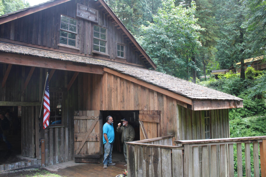 Cedar Creek Grist Mill caretaker Jeffrey Berry, left, talks to a visitor Saturday at the historic grain mill in Woodland.