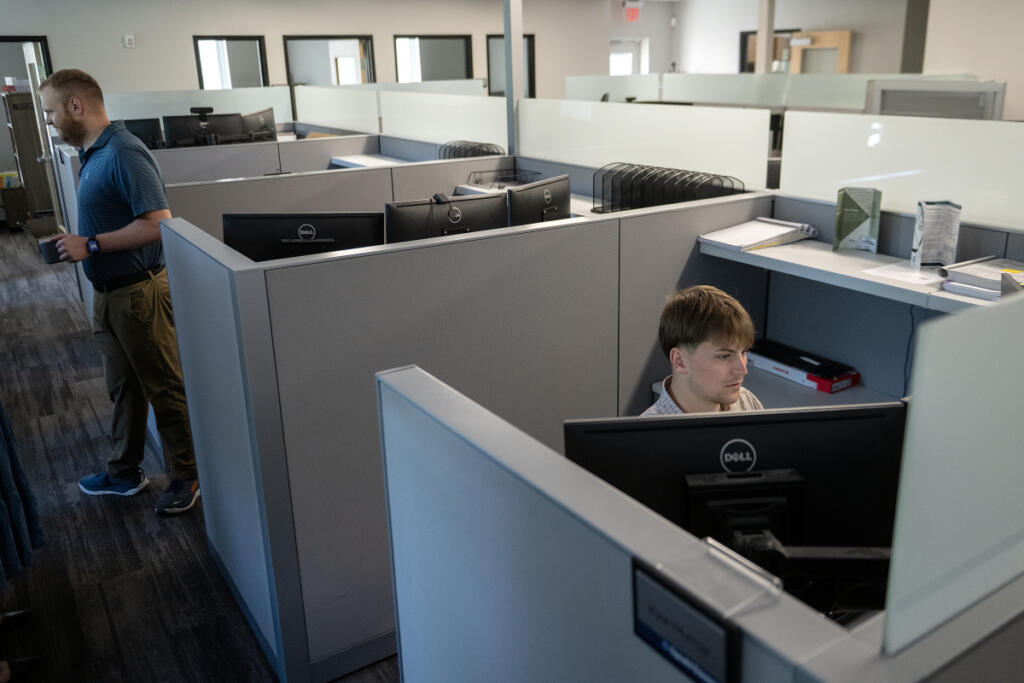 Drew Spear, left, of Opsahl Dawson, joins colleague Ryan Murray at work June 22. The local accounting firm is still growing, though not quite at the pace of a few years ago. (Photos by Amanda Cowan/The Columbian)