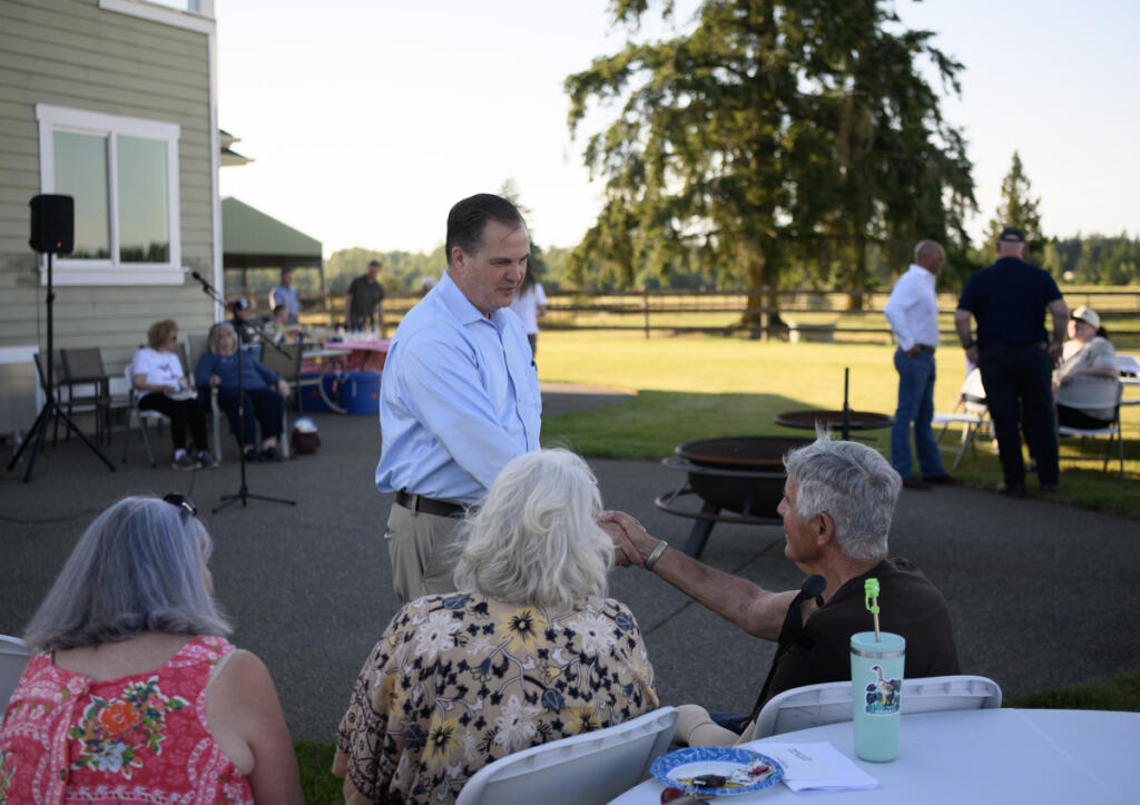 Washington state Sen. John Braun, R-Centralia, center, shakes hands during a June 23 rally for his 3rd Congressional District campaign at Merten Ranch in Toledo. (Taylor Balkom/The Columbian)