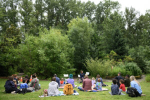Kids and adults sit on blankets and listen to a story read by educator Erin Bowen on Wednesday during a Reading in the Wild event at the Water Resources Education Center in Vancouver. (Photos by Taylor Balkom/The Columbian)
