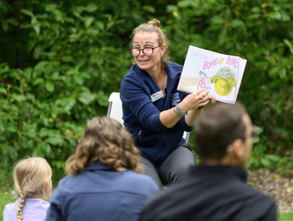 Educator Erin Bowen reads a story to parents and children on Wednesday during a Reading in the Wild event at the Water Resources Education Center in Vancouver. (Taylor Balkom/The Columbian)