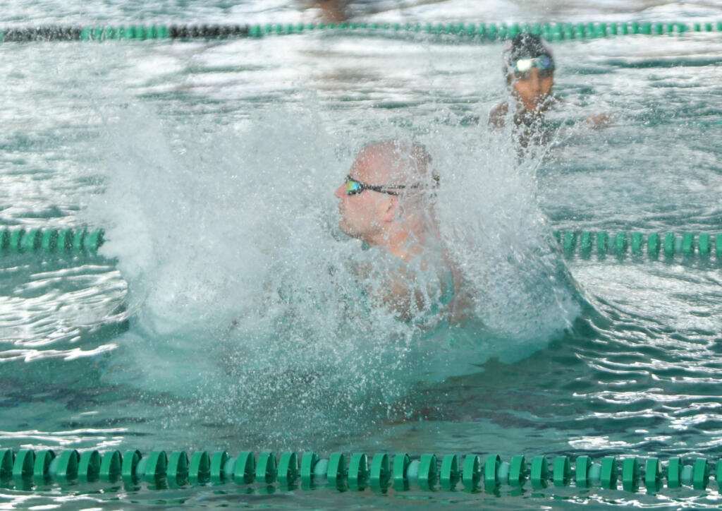 Camas High alumni swimmer Jace Yraceburu hits the water during the cannonball competition at the Camas Alumni swim meet Friday at Gold&rsquo;s Gym Camas. The meet helped raise $4,500 for the Camas High School swim program. (Tim Martinez/The Columbian)