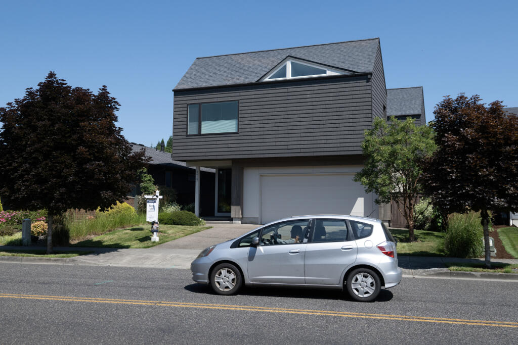 A motorist drives past a home for sale in Ridgefield on Monday morning. As the war in Iran rages on, inflation and interest rates remain high, keeping many buyers out of the real estate market. (Photos by Amanda Cowan/The Columbian)
