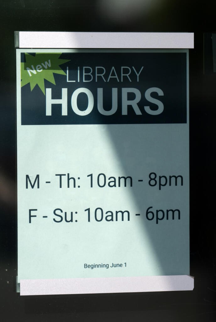A sign in the window of Three Creeks Community Library notifies the public of new hours on Tuesday morning. (Photos by Amanda Cowan/The Columbian)