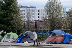 A train passes by a homeless encampment in downtown Vancouver in March. The number of people who accessed the Clark County&rsquo;s homeless system decreased slightly from 2024 to 2025, yet housing leaders say it remains a critical issue. (Amanda Cowan/The Columbian)