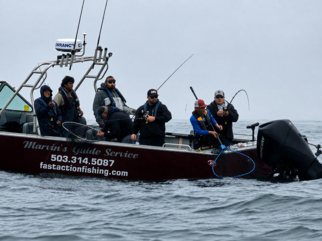 Fishing guide Marvin Henkel netting a salmon at Buoy 10. The action in the river and out in the ocean has been excellent this year. (Photo courtesy of Marvin&rsquo;s Guide Service)