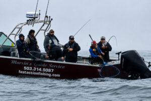 Fishing guide Marvin Henkel netting a salmon at Buoy 10. The action in the river and out in the ocean has been excellent this year. (Photo courtesy of Marvin&rsquo;s Guide Service)