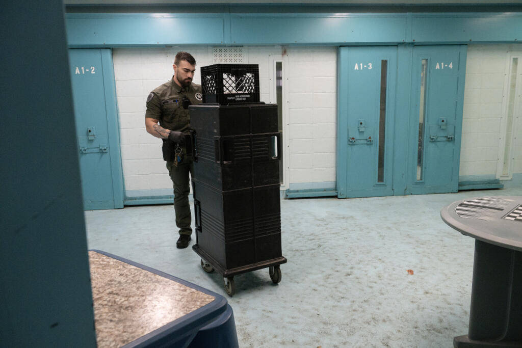 Officer Dante Lopez delivers lunch to inmates in the administrative segregation and suicide watch area of the Clark County Jail on July 2. (Photos by Amanda Cowan/The Columbian files)