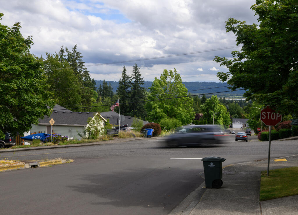 A car moves through the intersection of W and 42nd streets on June 30 in Washougal. Resident Tim Taylor has been fighting to get speeding under control along W Street since 2021. (Taylor Balkom/The Columbian)