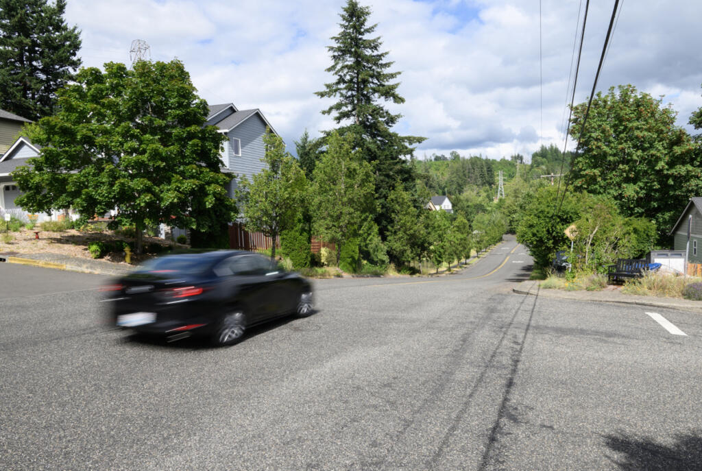 A car moves through the intersection of W and 42nd streets on June 30 in Washougal. Resident Tim Taylor has been fighting to get speeding under control along W Street since 2021. (Taylor Balkom/The Columbian)